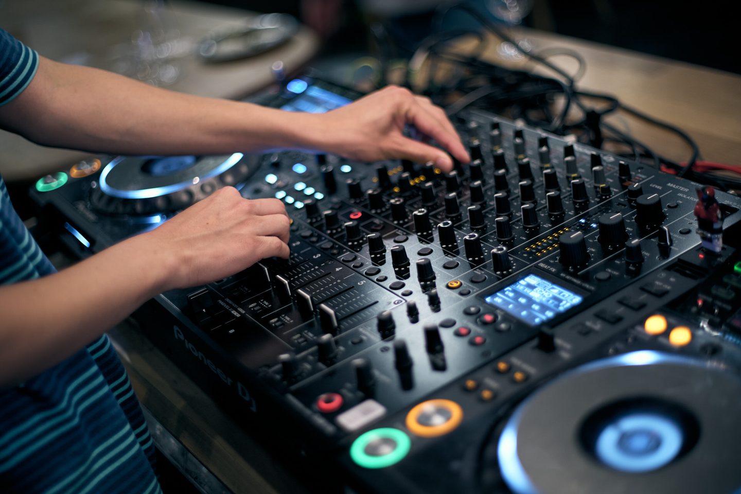 ターンテーブルに手を添えるDJ