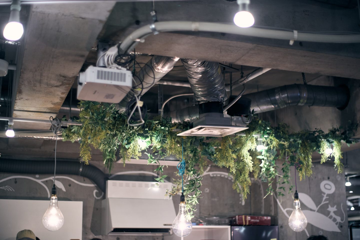 天井に吊るされた植物と配管