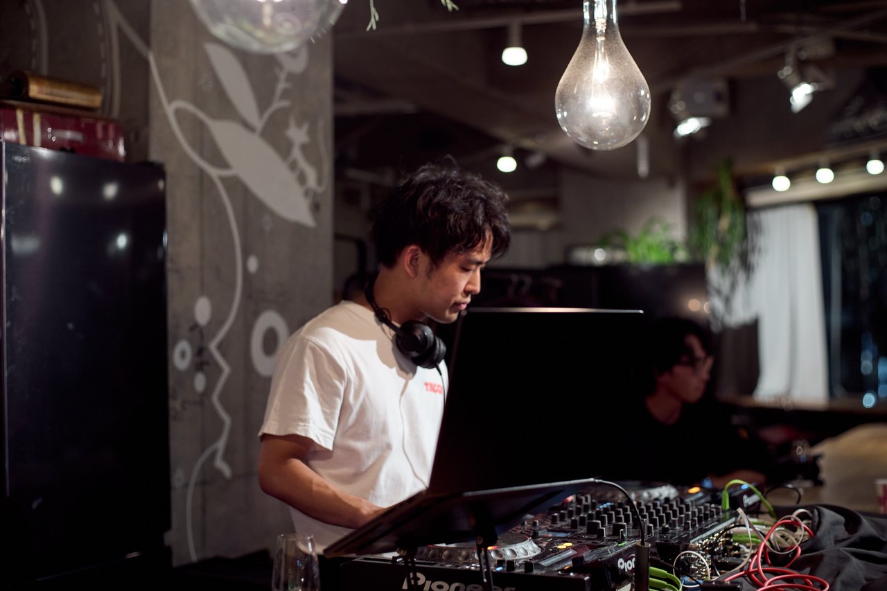 ヘッドフォンを首にかけプレイするDJ