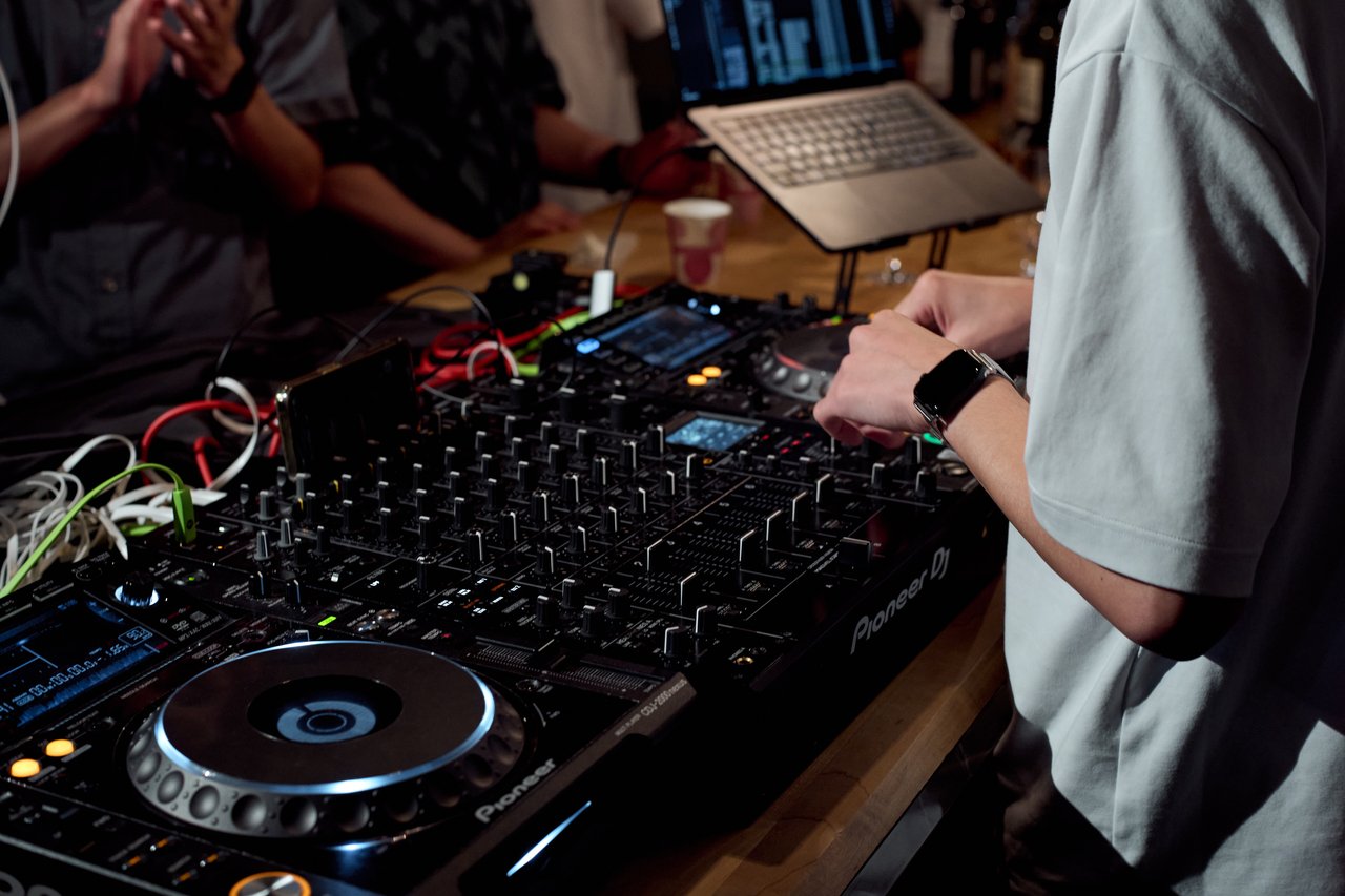 ミキサーに手を添えるDJ