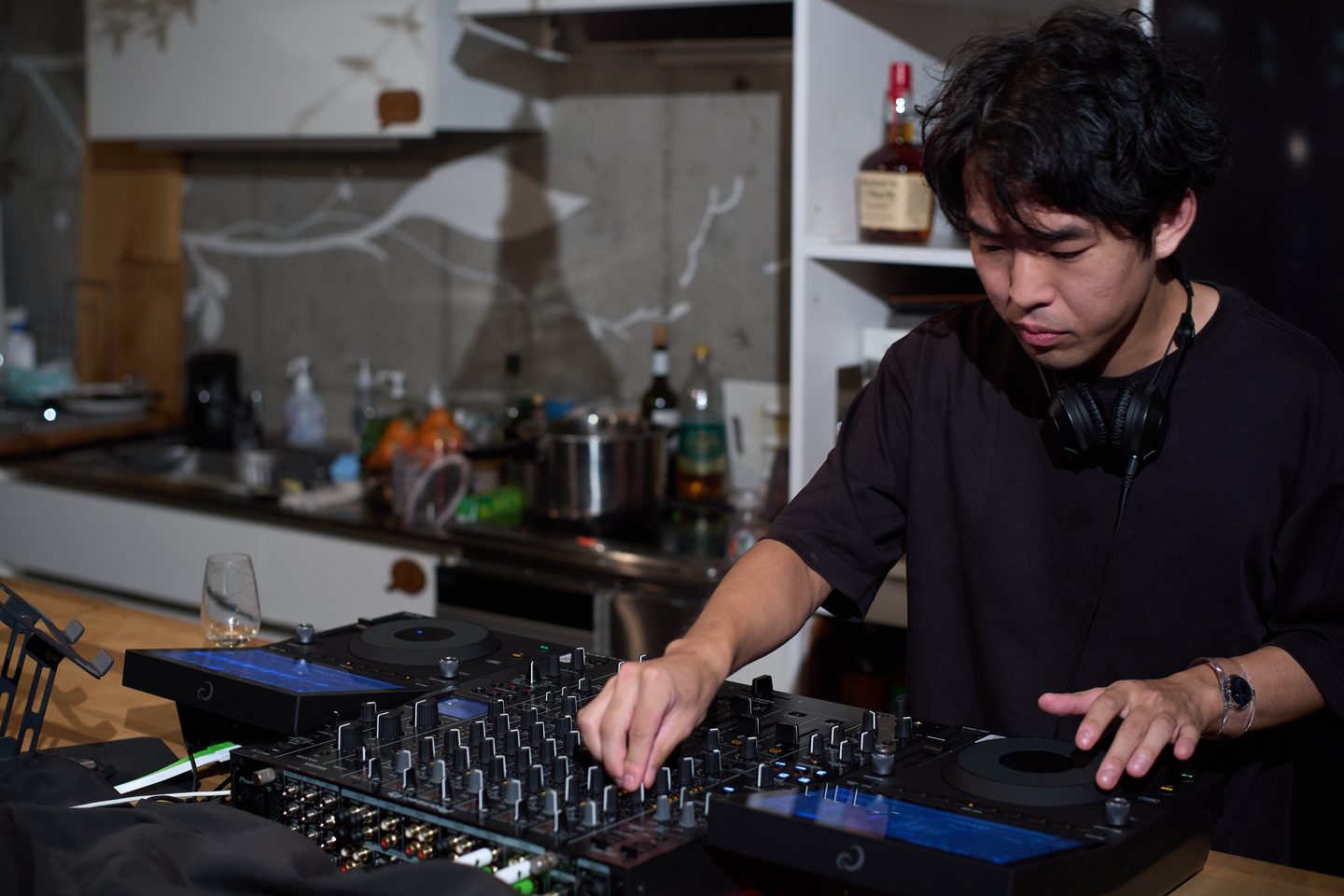 ミキサーに手を伸ばすDJ